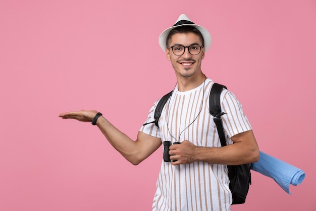 ピンクの背景に双眼鏡と白いTシャツの正面図若い男性