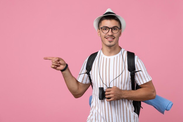 ピンクの背景に双眼鏡と白いTシャツの正面図若い男性