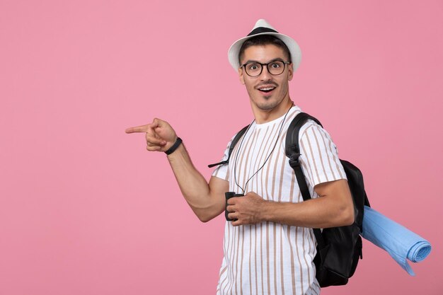 Front view young male in white t-shirt with binoculars on the pink background