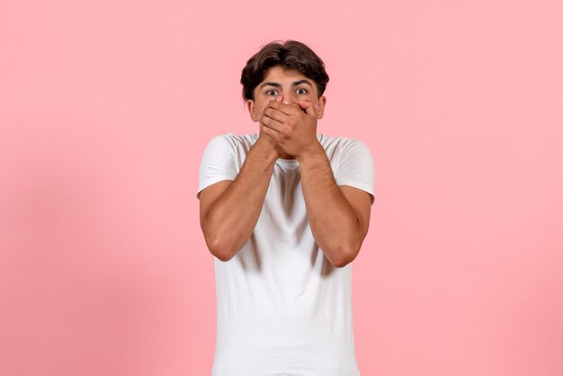 Front view young male in white t-shirt with shocked face on pink background