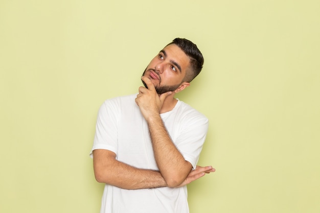 A front view young male in white t-shirt with thinking expression