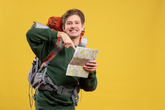 無料写真 地図を保持しているバックパックを持つ若い男性の正面図