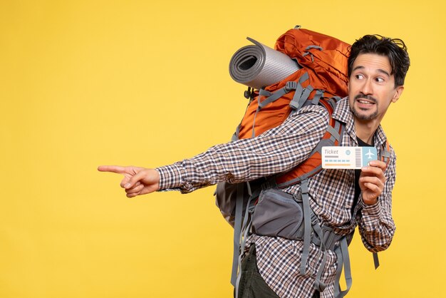 Front view young male with backpack holding ticket on yellow 