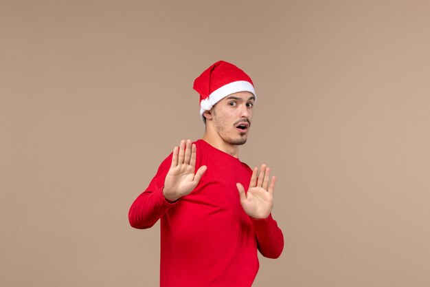 Front view young male with cautious expression on brown background emotion christmas holiday