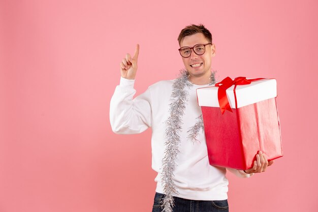 Front view young male with christmas present on pink background