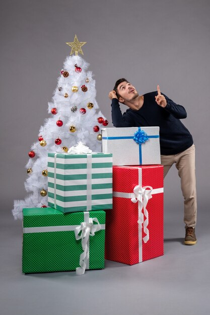 Front view young male with christmas presents on grey