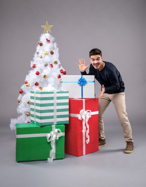 Вид спереди молодой самец с рождественскими подарками на свете