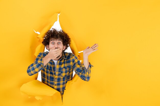 Front view young male with curly hair on the yellow ripped background