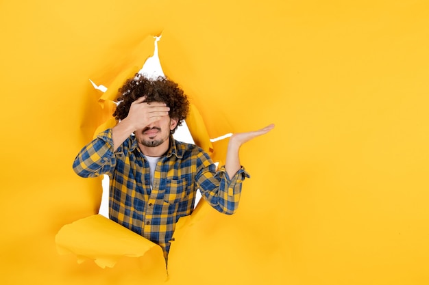 Front view young male with curly hair on yellow ripped background