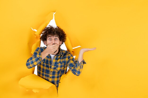 Front view young male with curly hair on yellow ripped background