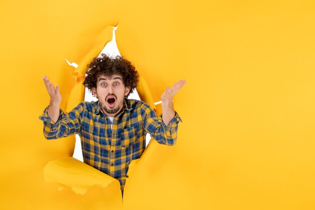 Front view young male with curly hair on yellow ripped background