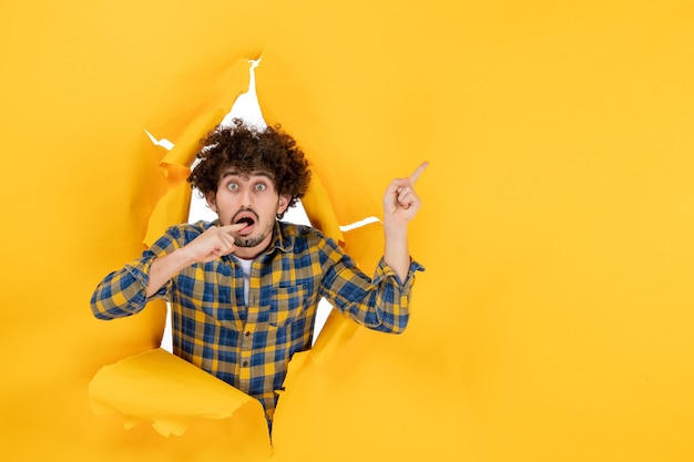 Front view young male with curly hair on yellow ripped background