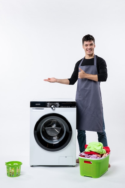 Free photo front view of young male with dirty clothes and washer on white wall