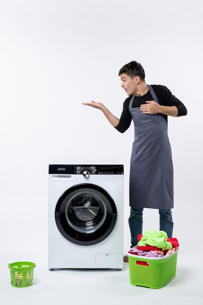 Free photo front view of young male with dirty clothes and washer on white wall