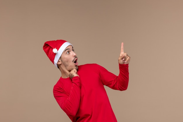 Free photo front view young male with excited expression on brown background christmas emotion holiday male