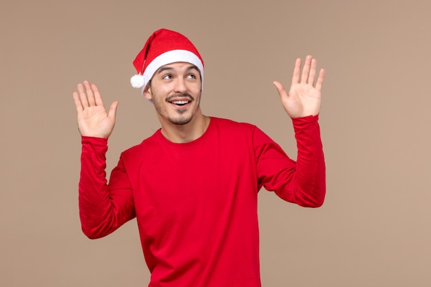 Front view young male with excited expression on the brown background christmas holiday emotion