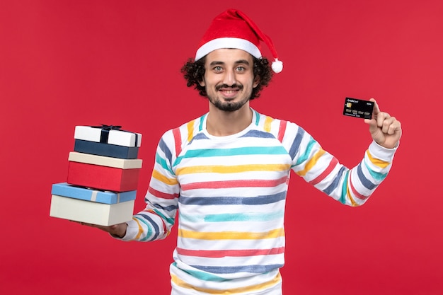 휴일 선물 및 빨간 벽 새 해 돈 빨간색에 은행 카드 전면보기 젊은 남성