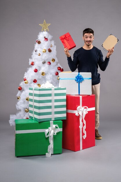 Front view young male with holiday presents on grey floor human new year xmas gift