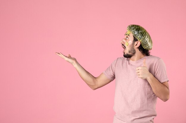 front view young male with mask on his face on pink background