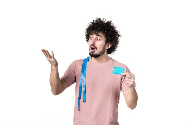 Front view young male with measure tape holding credit card on white surface