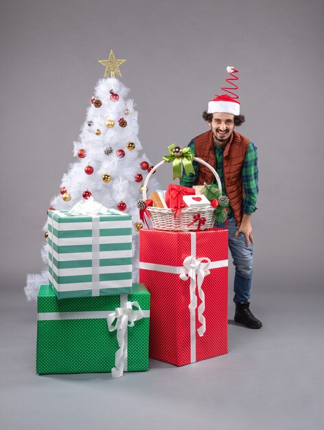 Front view young male with mic around presents on a grey 