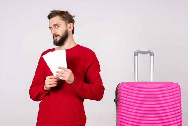 Front view young male with pink bag and holding tickets on white wall trip color vacation flight summer tourist