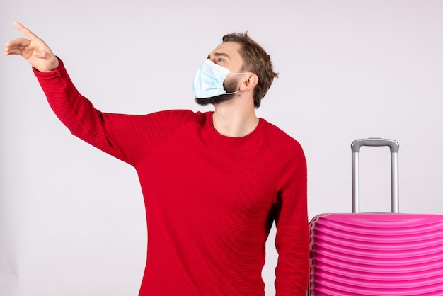 흰 벽 항해 covid- 비행 여행 휴가 감정 바이러스에 마스크에 분홍색 가방 전면보기 젊은 남성