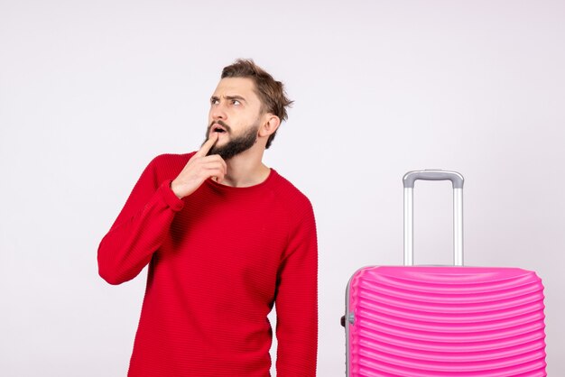 Front view young male with pink bag on white wall trip photo human color vacation flight voyage