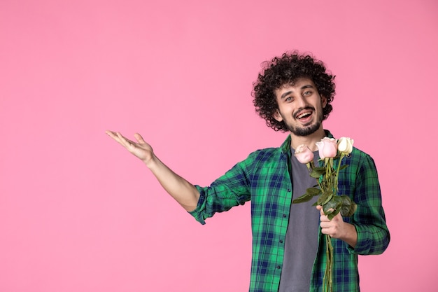 Vista frontale giovane maschio con rose rosa su rosa