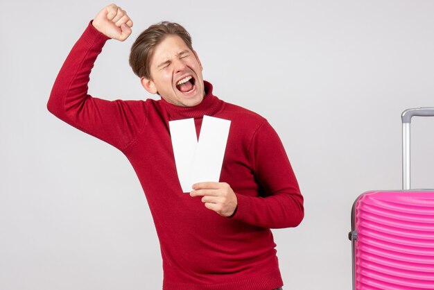 Front view young male with plane tickets rejoicing on white background