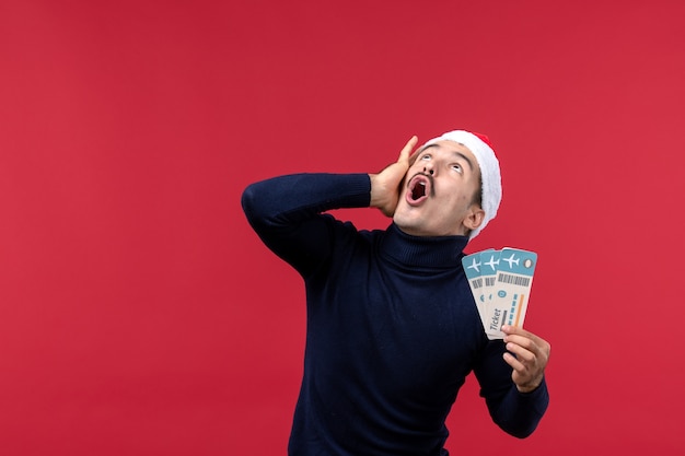 Front view young male with plane tickets scared on red background