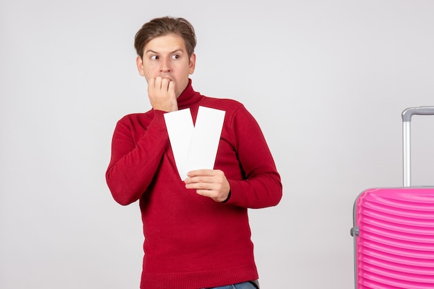 Front view young male with plane tickets scared on white background