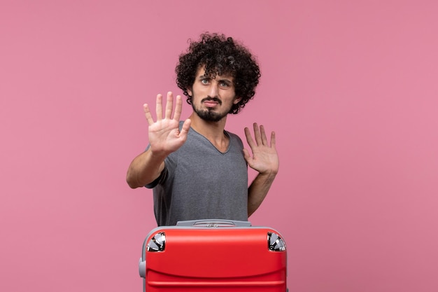 Free photo front view young male with red bag posing on light-pink space