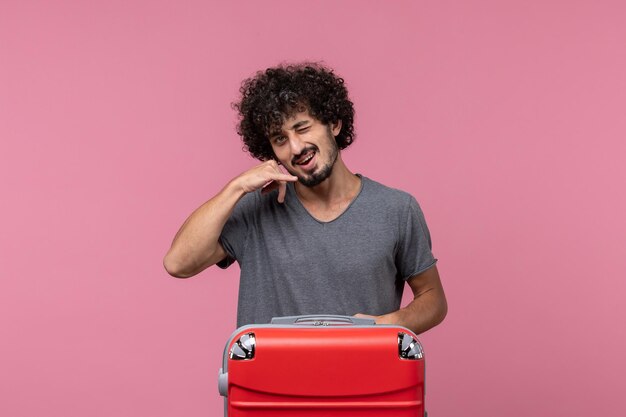 Front view young male with red bag posing on a pink space