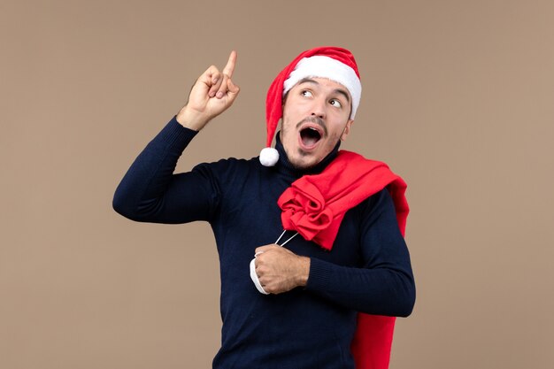 Front view young male with red cap and present bag, holiday christmas santa