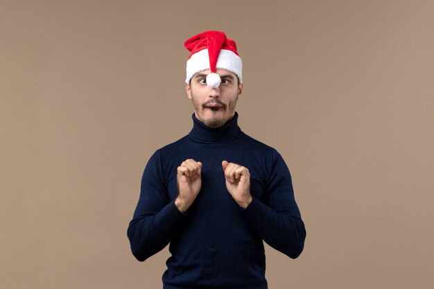 Front view young male with red christmas cap on brown desk holiday christmas