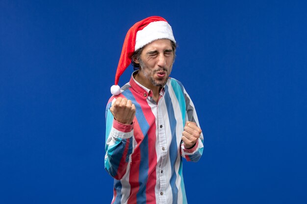 Front view young male with red christmas cap, holiday male emotions