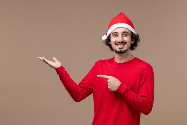 갈색 배경 감정 휴일 크리스마스에 빨간 크리스마스 케이프와 전면보기 젊은 남성