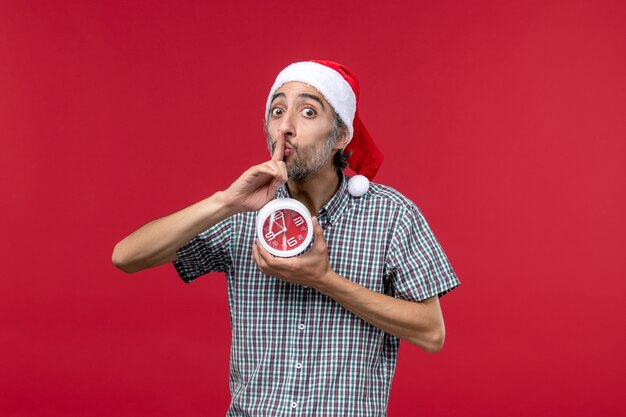 Front view young male with round clocks on a red background