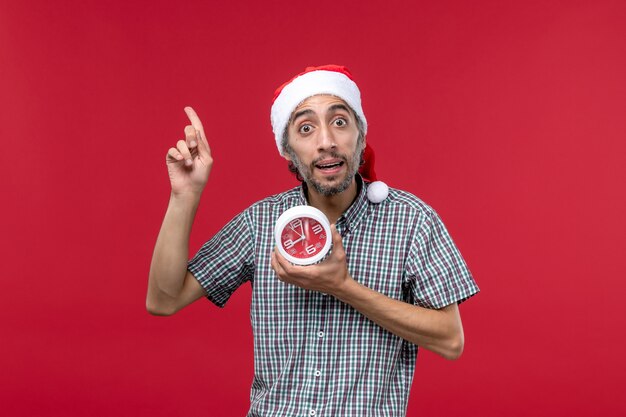 Front view young male with round clocks on a red background