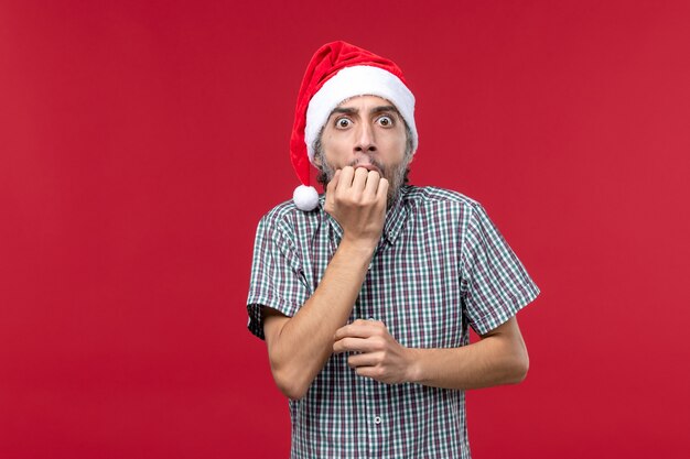 Front view young male with scared expression on red background