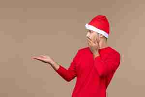 Free photo front view young male with surprised face on brown background christmas emotion holiday