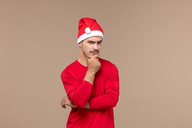 Front view young male with thinking expression on brown background male emotion holiday colors