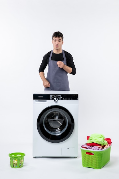 Free photo front view of young male with washer and dirty clothes on white wall