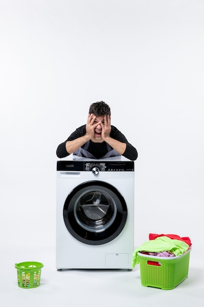 Free photo front view of young male with washer and dirty clothes on white wall