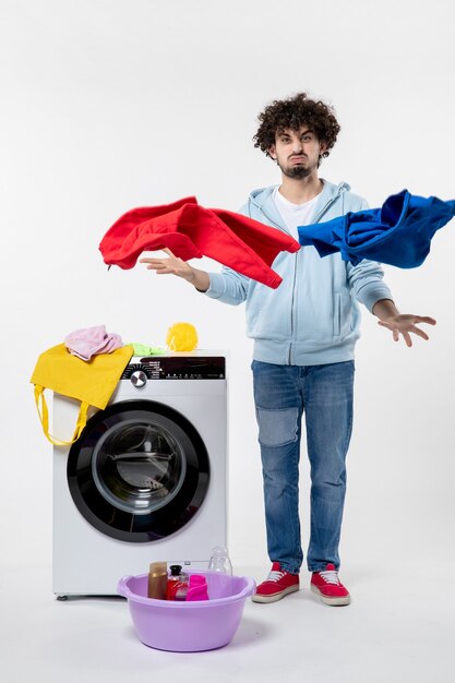 Free photo front view of young male with washer and dirty clothes on white wall