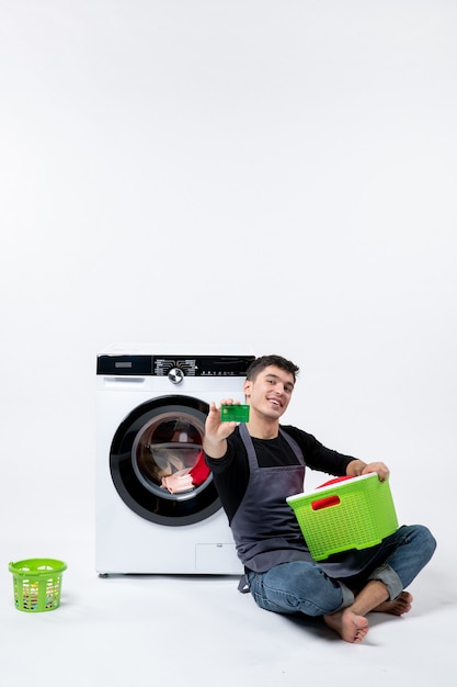 Free photo front view of young male with washer holding green bank card on light wall