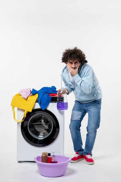 Free photo front view of young male with washer holding liquid powder on white wall