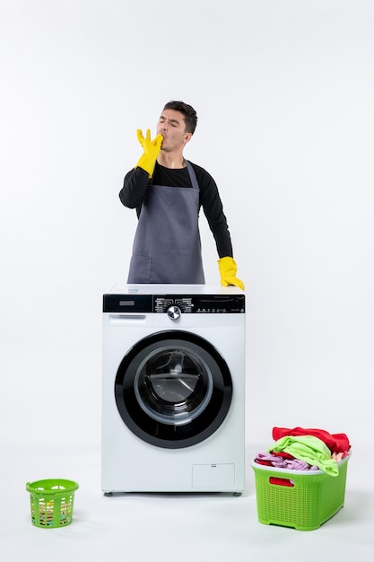 Free photo front view of young male with washing machine and dirty clothes on white wall