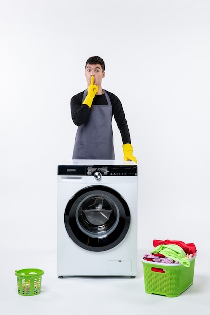 Free photo front view of young male with washing machine and dirty clothes on white wall